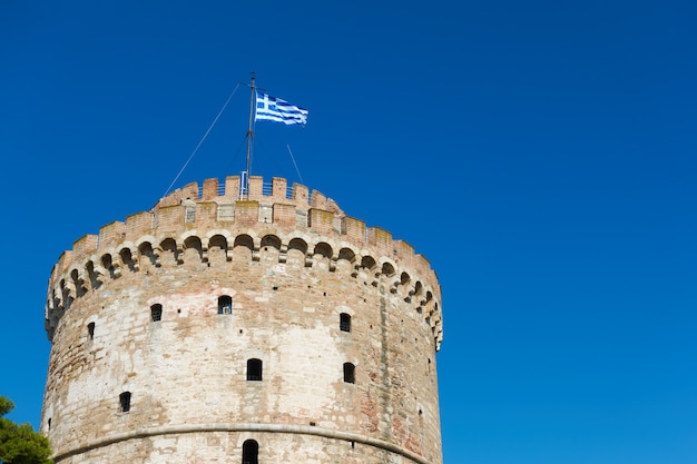 A torre branca em thessaloniki, com a bandeira grega, na grécia. marco grego