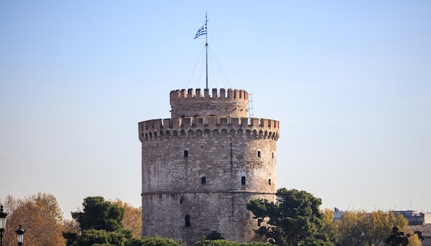 A Torre Branca em Thessaloniki Grécia Árvores ao seu redor Fundo claro do céu azul