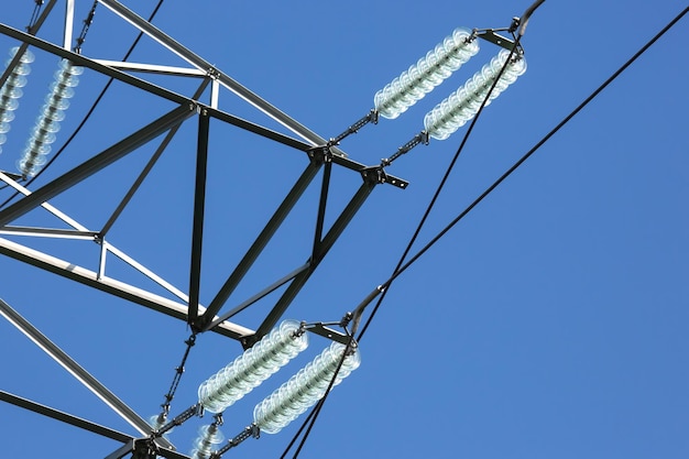 A torre de alta tensão com fios de tensão elétrica isola o close-up contra o fundo das nuvens Indústria de energia