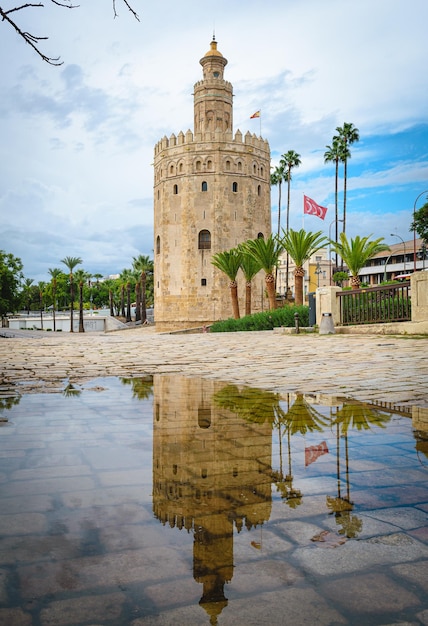 A Torre del Oro Gold Tower em Sevilha refletida em uma poça de água