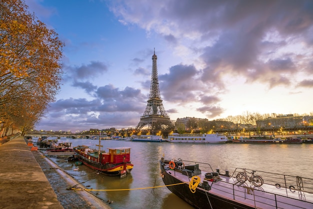 A Torre Eiffel e o Rio Sena ao entardecer em Paris, França.