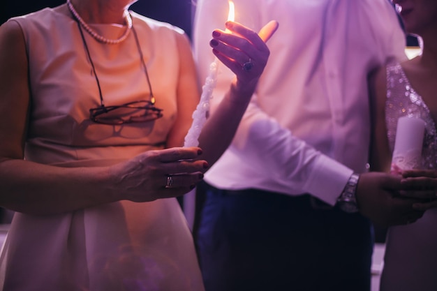 a tradição do casamento da transferência de fogo da família. recém-casados e seus pais seguram velas