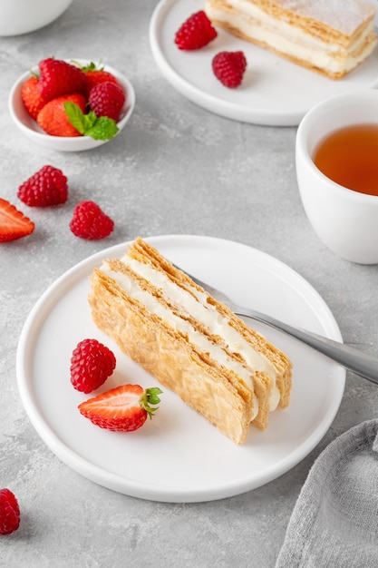 Foto a tradicional sobremesa francesa millefeuille com creme de baunilha e bagas frescas em um prato branco