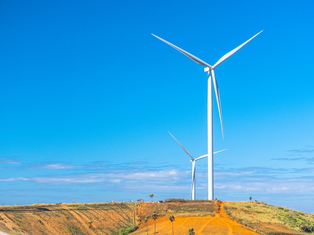 A turbina eólica da eletricidade gera bonde com o céu azul no fundo.