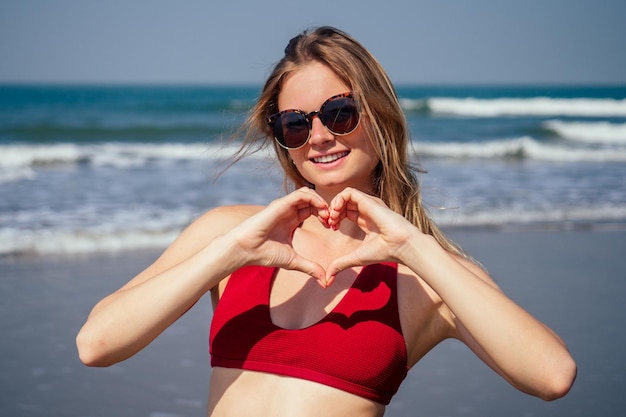 A turista feminina gosta de tempo livre ao ar livre perto do oceano na praia olha para a câmera selfie Feliz turista sorridente nos trópicos