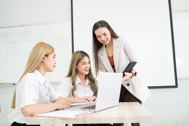 A universidade de estudantes asiáticas do grupo explica e apresenta com professora professora na sala de aula