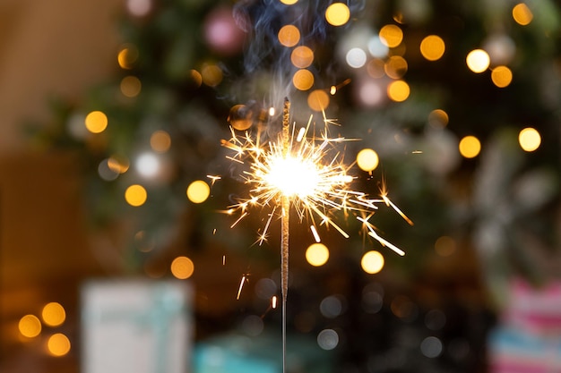 A vela cintilante de Natal queima no fundo da árvore de natal decoração de iluminação de natal em