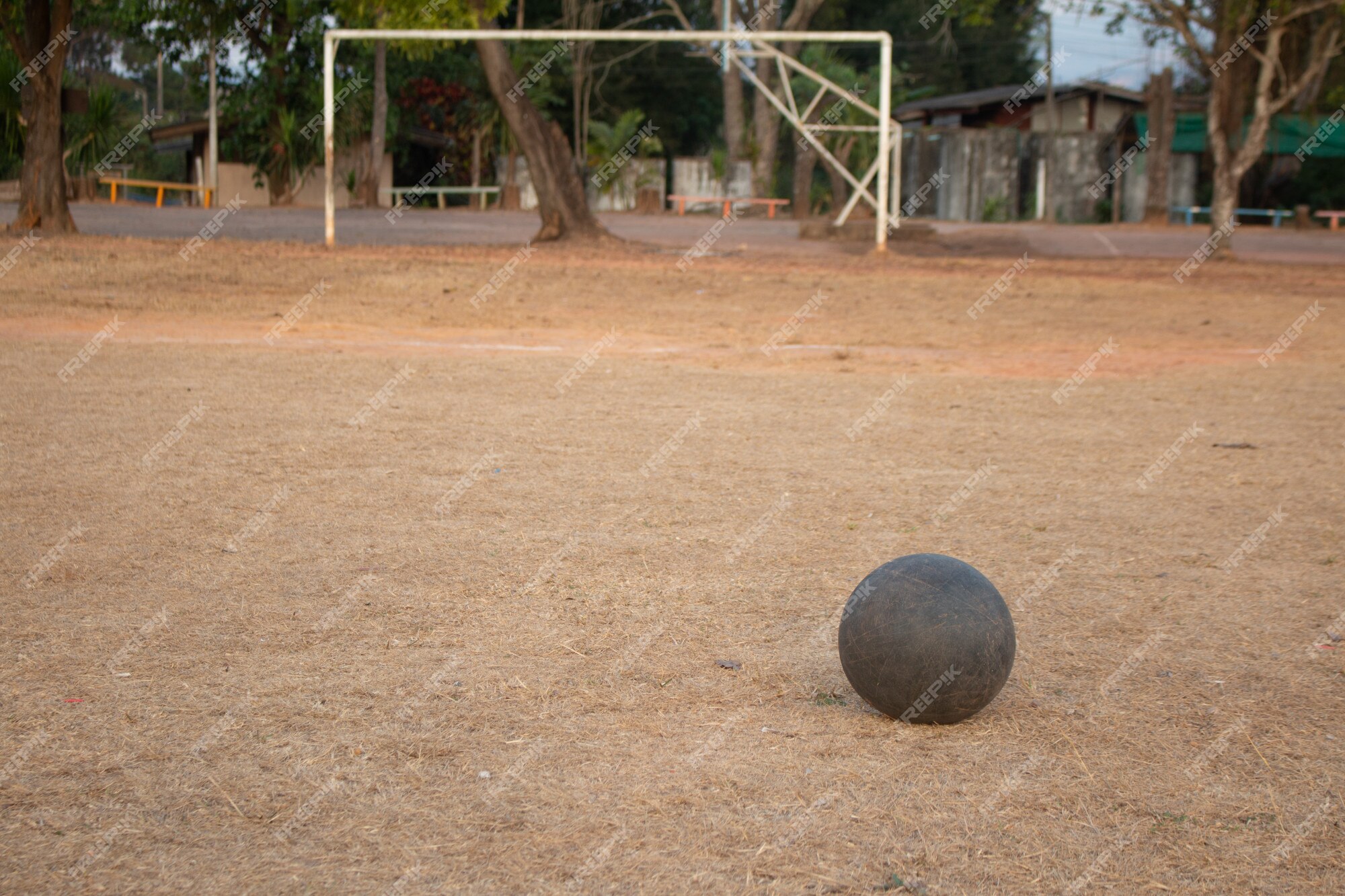 A velha bola de futebol na grama pior, pobre campo de jogo de futebol na  zona rural