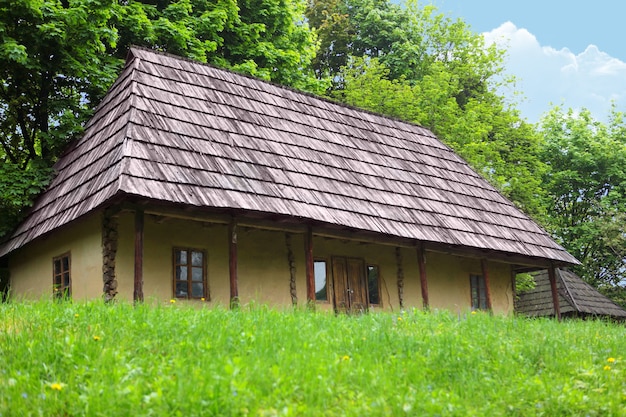 A velha casa de madeira localizada na orla da floresta.