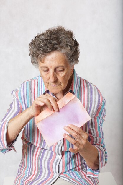 A velha mantém uma carta nas mãos