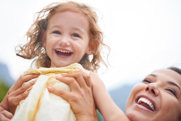 A vida é uma aventura Foto recortada de uma mãe alegre levantando sua filha para o céu