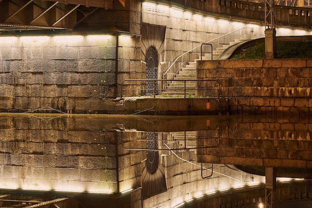 A visão noturna do rio Aura em Turku Finlândia com uma ponte em um fundo