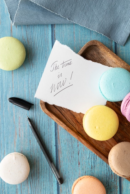 A vista de cima da época agora é uma citação inspiradora com macarons e caneta