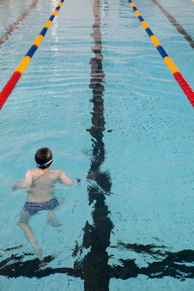 A vista de uma piscina pública no interior Pistas de uma competição Menino treinando em uma piscina