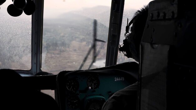 A vista do clipe do helicóptero o piloto controla o helicóptero sobre uma grande floresta verde em