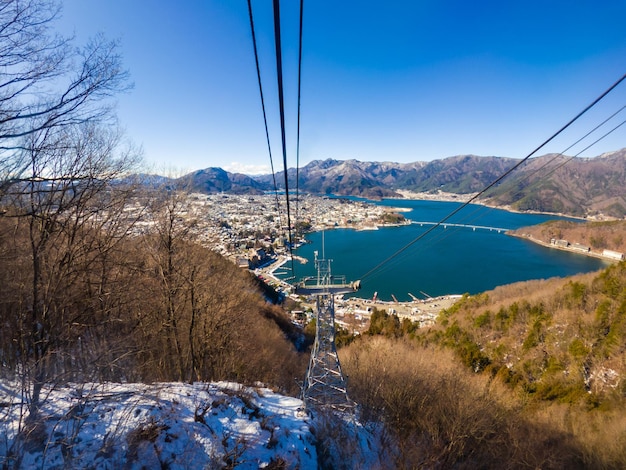 A vista do lago Kawaguchiko e a montanha de neve na cidade de Fujioshida são tiradas do teleférico no dia ensolarado com o céu azul claro na temporada de inverno