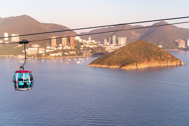 A vista ensolarada do teleférico e do parque temático perto do oceano