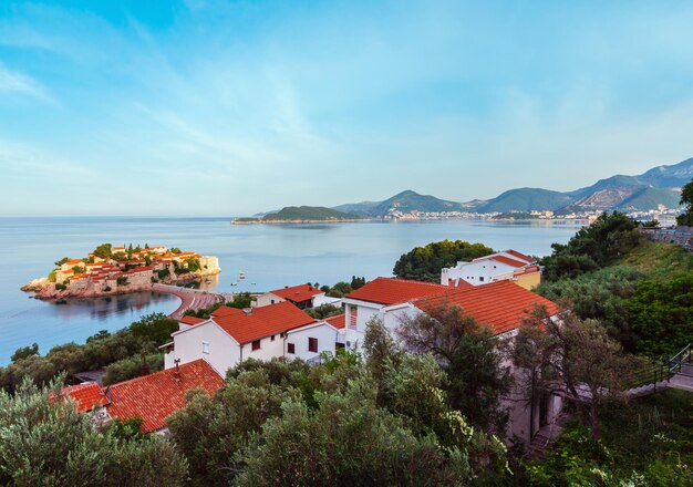 A vista matinal da ilhota marítima de Sveti Stefan com praia rosa Montenegro perto de Budva