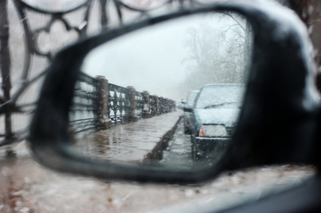 A vista no espelho retrovisor lateral do carro em condições climáticas adversas