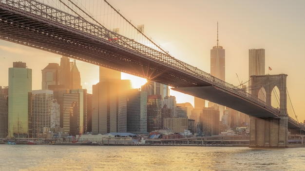 A vista panorâmica da ponte de Brooklyn com Lower Manhattan ao pôr do sol nos EUA