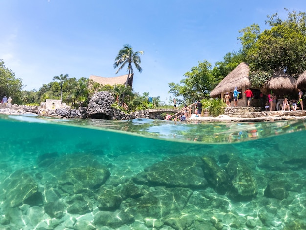 Foto a vista subaquática dividida na lagoa de mergulho no parque xcaret no resort maia riviera xcaret é um