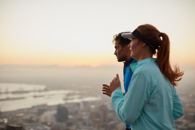 A vista torna a corrida tão gratificante Foto de um jovem casal atlético saindo para correr pela manhã