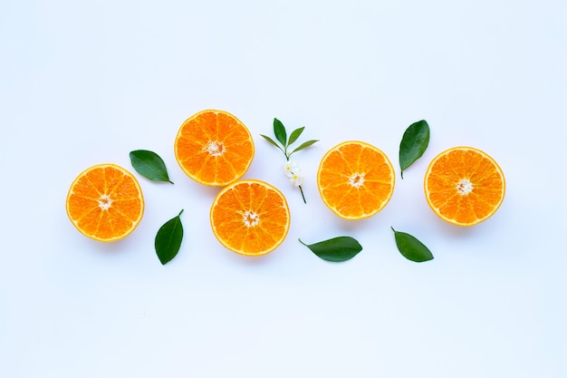 A vitamina alta C, laranja frutifica com as folhas no fundo branco.