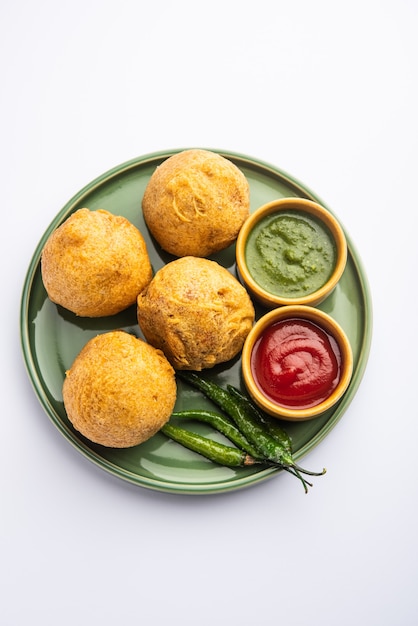 Aalu bonda es un pakora indio o batata vada servido con salsa de tomate