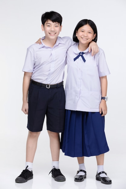 Aasian menina e menino em uniforme de estudante em cinza