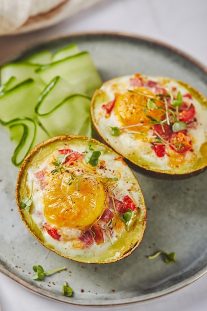 Abacate assado com ovo presunto, tomate e queijo ceto receita de almoço após o cozimento