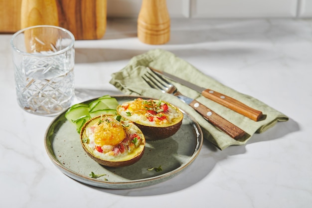 Abacate assado com ovo presunto, tomate e queijo ceto receita de almoço após o cozimento