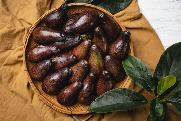 Abacate em bandeja de madeira com fundo marrom