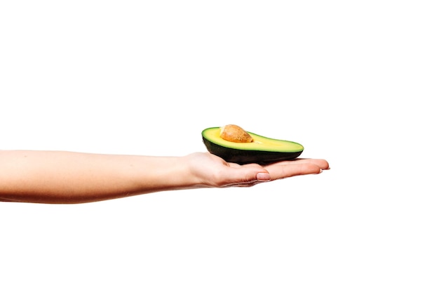 abacate em uma mão feminina em um fundo branco