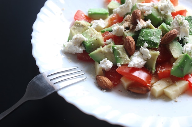 Abacate fresco deliciosa salada mediterrânea com tomate cereja e amêndoas e queijo feta parmesão