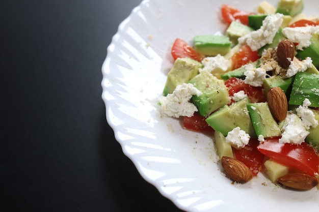 Abacate fresco deliciosa salada mediterrânea com tomate cereja e amêndoas e queijo feta parmesão