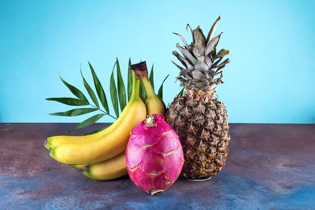 Foto abacaxi assorted dos frutos tropicais, manga, fruta do dragão, no fundo de pedra. grupo de frutas tropicais exóticas.