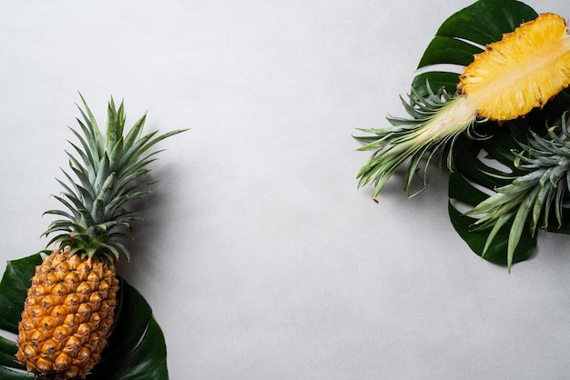 Abacaxi fresco cortado com folhas tropicais em fundo azul escuro