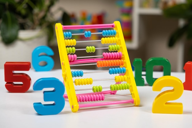 Foto Ábaco colorido para niños en la mesa matemática aritmética para niños en edad preescolar y escolar aprendiendo a contar