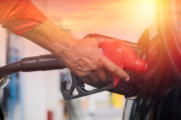 Abastecimento do carro no posto de gasolina Reabastecer com gasolina gasolina Bomba de gasolina enchendo o bocal de combustível no tanque de combustível do carro no posto de gasolina Indústria de petróleo