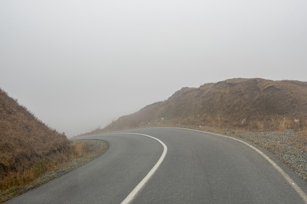 Abbiegen auf eine Bergstraße im Nebel Highway durch den Pass im dichten Nebel