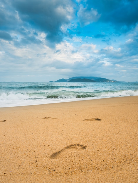 Abdruck auf dem Strand mit Insel nach. Stimmungsvoller Himmel Wand