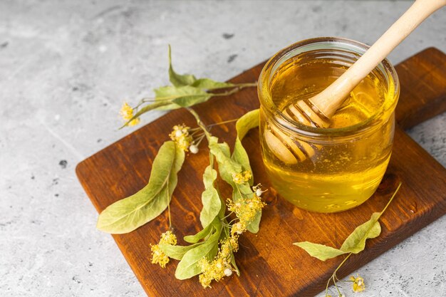 Abelha isolada em frasco de vidro e com concha de mel no fundo branco