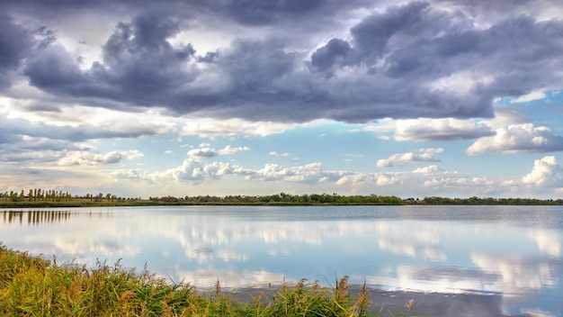 Abend Sommerlandschaft mit üppigen Kiefer am Ufer des Flusses