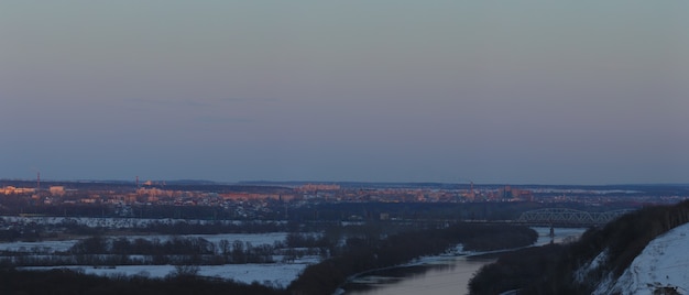 Abendbeleuchtung über der Stadt. Sonnenuntergang am Dämmerungshimmel. Panoramablick von oben auf das Wohnviertel.