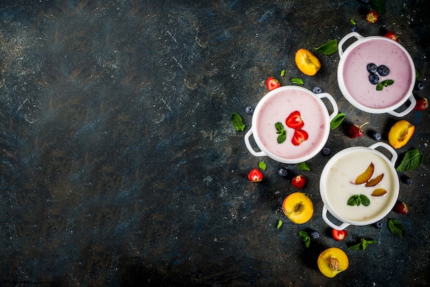 Abendessen mit gesunder Ernährung, veganes Essen, Dessert, verschiedene süße cremige Obst- und Beerensuppen - Erdbeere, Pfirsich, Heidelbeere