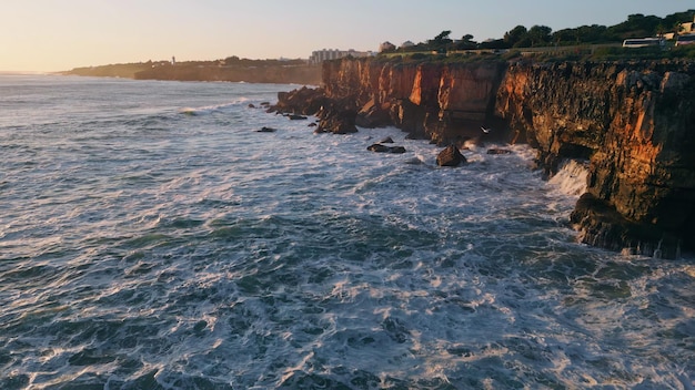 Abendlandschaft, felsige Küste mit schäumendem, wellenförmigem Meerwasser, Luftansicht