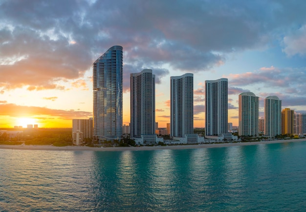 Abendliche Landschaft mit Sandstrand in der Stadt Sunny Isles Beach mit luxuriösen Hochhaushotels und Eigentumswohnungen am Atlantikufer Amerikanische Tourismusinfrastruktur in Südflorida