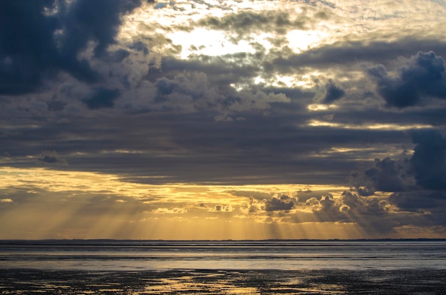 Abendlicht durch die Wolken vom Strand Bucht von Saint Michel in der Normandie