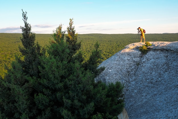 Abends fotografiert der Fotograf die Landschaft auf dem Felsen.