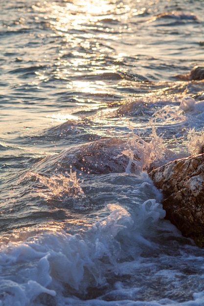 Foto abends schlagen wellen an einem felsigen strand.